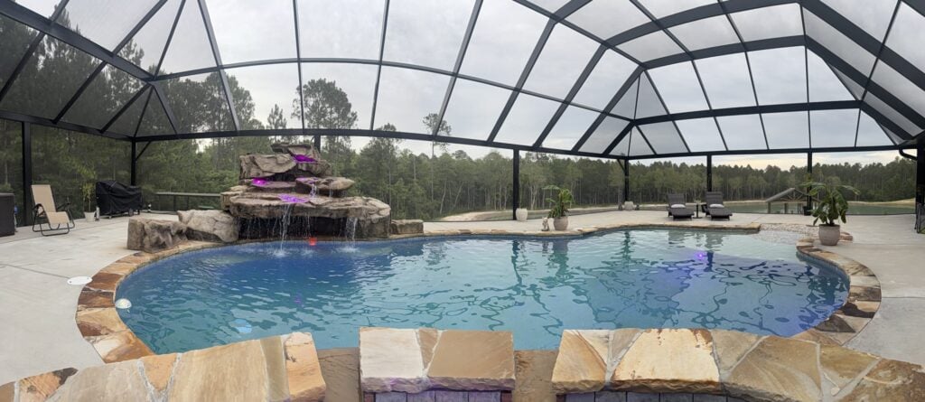 Screened enclosure over a resort-style pool and waterfall